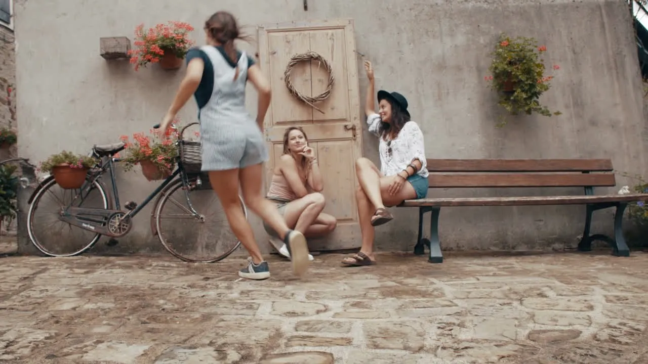 Three women chatting beside a wooden doorway on a cobbled street